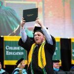 Arkansas Tech Announces 2018-19 Graduates A student proudly holds a diploma over his head after receiving it in the graduation ceremony