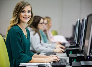 ATU-Ozark to Begin New Online Associate’s Degree Program in Fall 2019 A student sits in a computer lab and looks directly at the camera