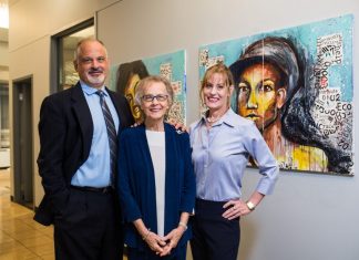Alumni Profile: David Sue & Anna Kay Freauff David, Sue, and Anna Kay Frueauff stand together next to a painting that incorporates gesture and text