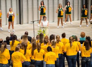 New Facility Made Possible Through Philanthropy A crowd of green and gold gathers to hear a speaker at the podium