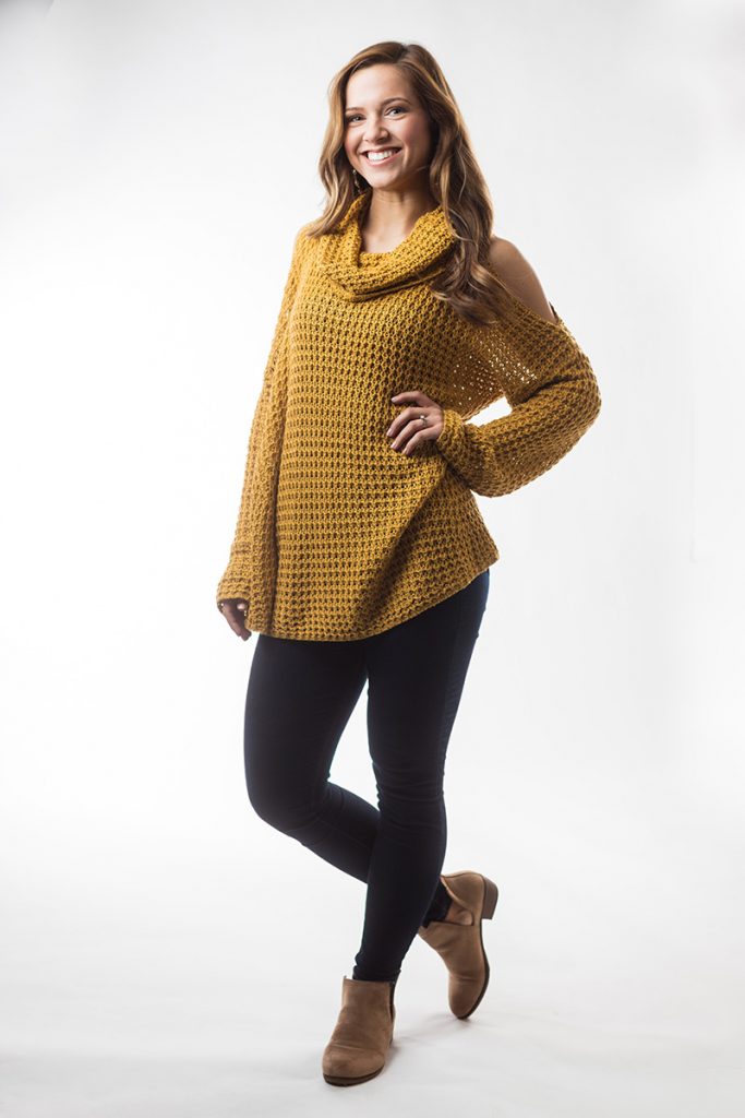 Student Carliegh Powell wears a knitted top and stands with a hand on her hip Student Carliegh Powell wears a knitted top and stands with a hand on her hip