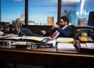 Arkansas’ Advocate Cory sits with his boots propped on the desk