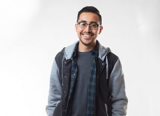 Student Stories: Carleigh Powell & Elmer Evangelista Student Elmer Evangelista is featured against a white backdrop wearing glasses and casual attire