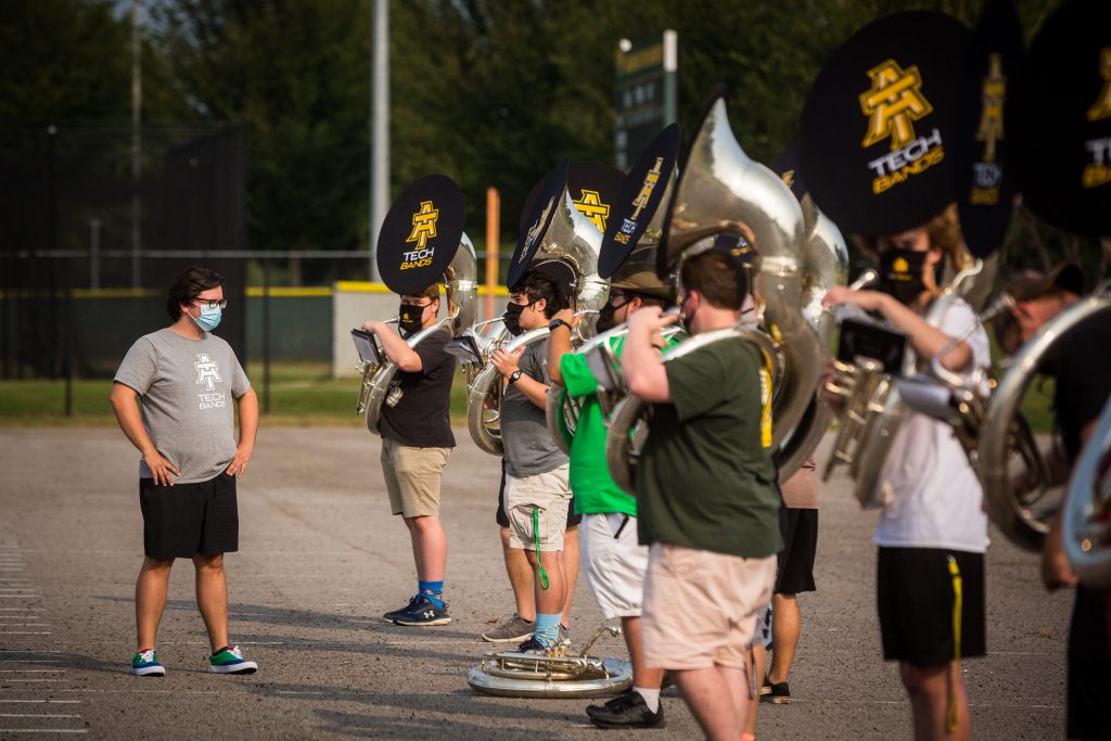 Michael Barker giving directions to the sousaphone line during outdoor practice.